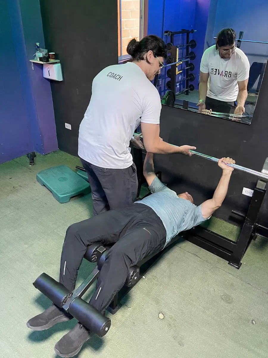 Entrenador de Brave Gym guiando un ejercicio en banco